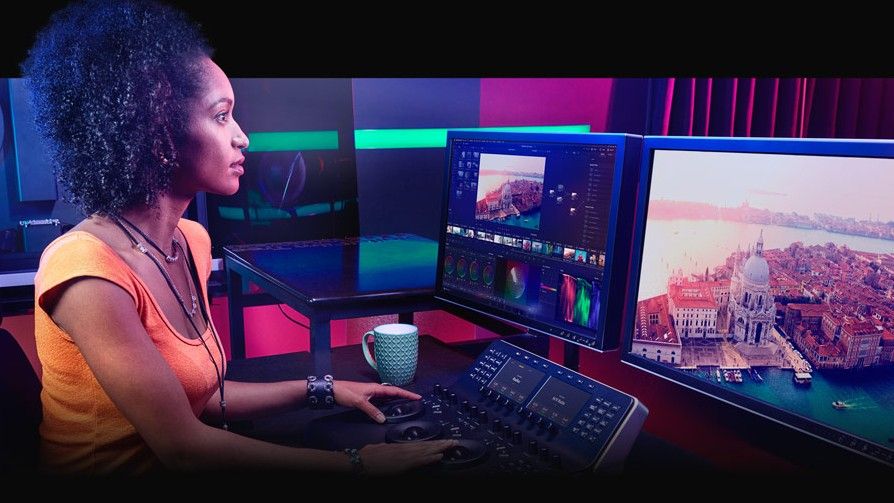 Woman using Da Vinci Resolve, one of the best free video editing software, on dual monitors