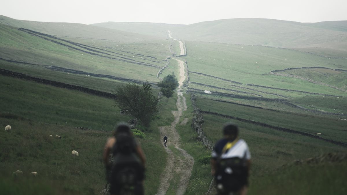 Cam High Road extends upwards infront of two cyclists