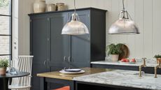 Black pantry, kitchen island, pendant lamps