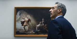 John Turturro as Irving standing in front of a painting