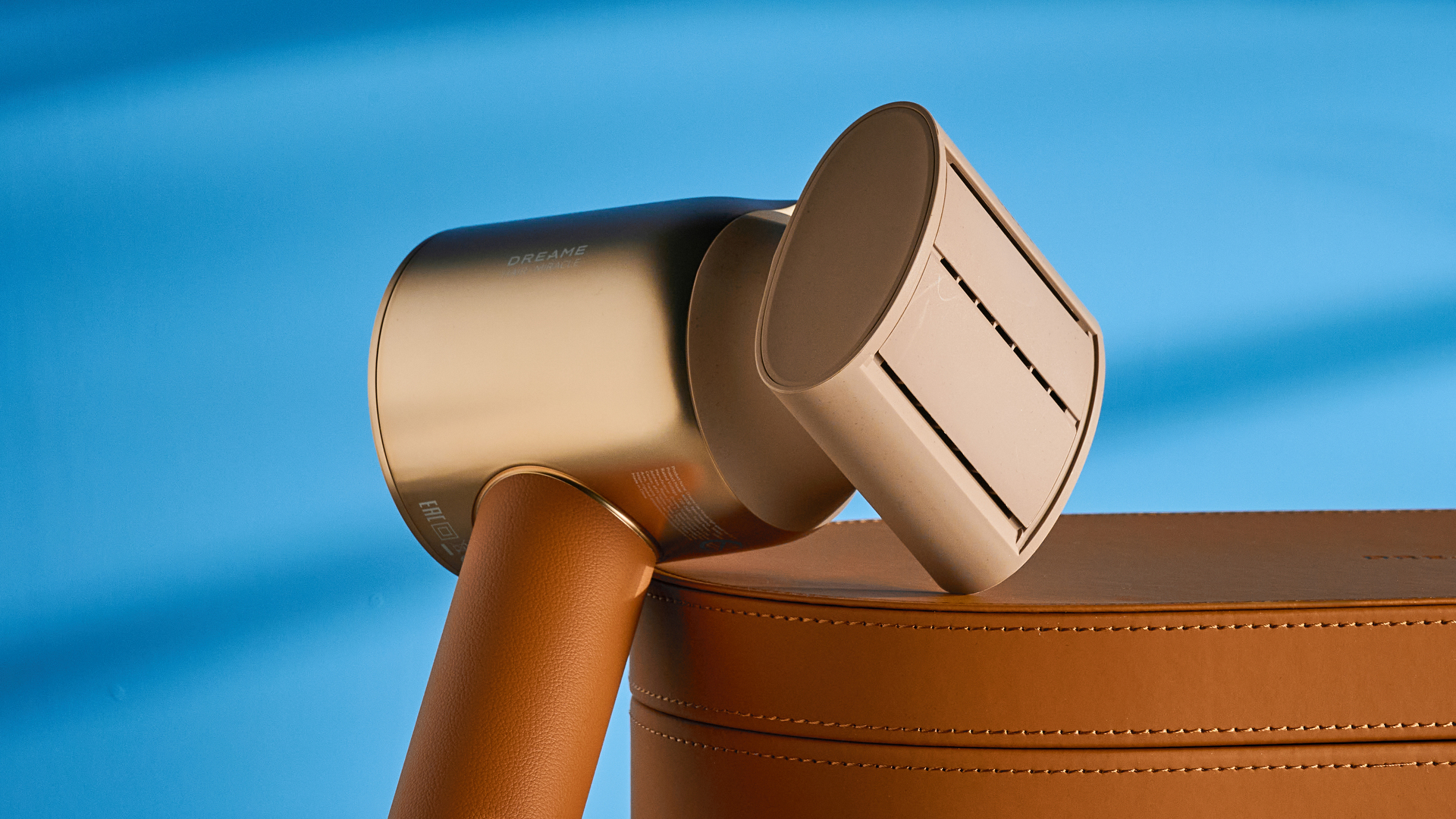 the dreame miracle pro hair dryer in gold showing the storage box on the blue tom's guide background, with the four attachment nozzles including two blow-drying nozzles, diffuser, and the flyaway tamer