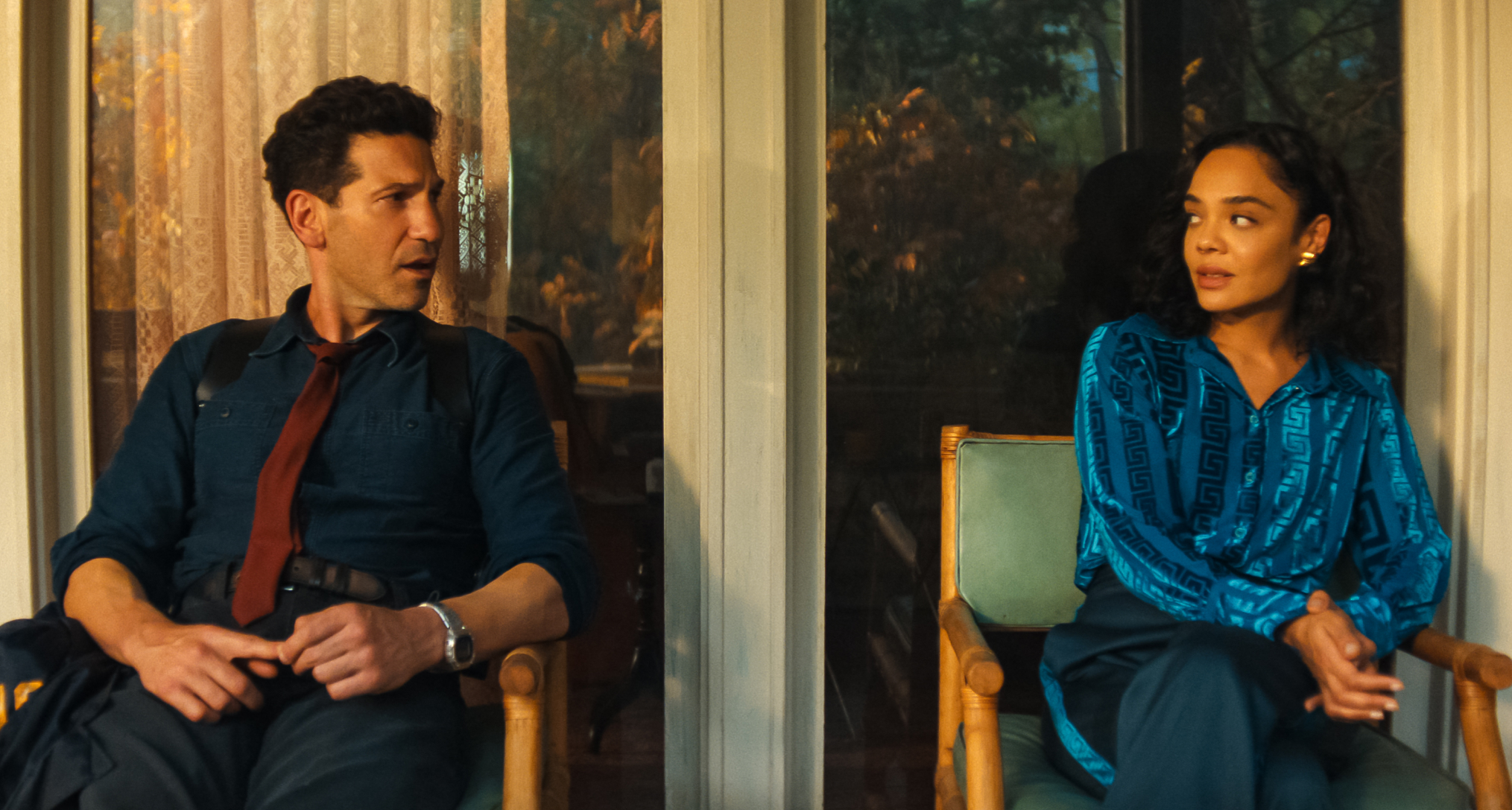 jon bernthal as jack and tessa thompson as anna sitting on a front porch looking at each other in a still from netflix's his and hers