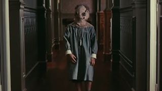 Tomas walking down the hallway with a sack on his head in The Orphanage