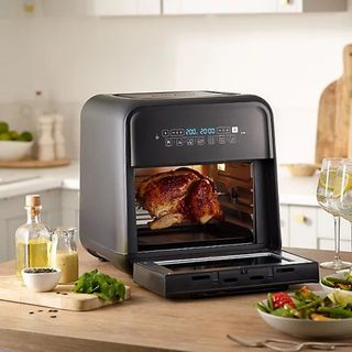 Breville Halo Air Fryer in Black with whole chicken on rotisserie spit