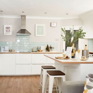 kitchen with white wall wooden flooring, white cabinets and white counter