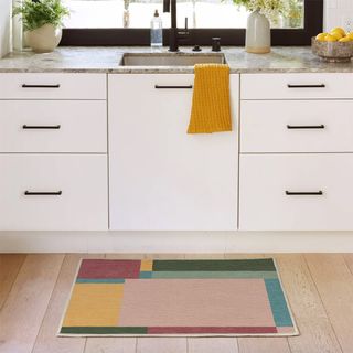 white kitchen with Pantone™ colour block mat in front of the sink