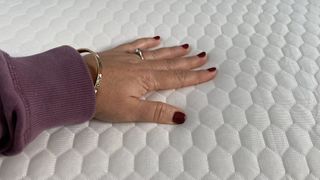 The tester feels the plushness of the Helix GlacioTex Mattress Topper