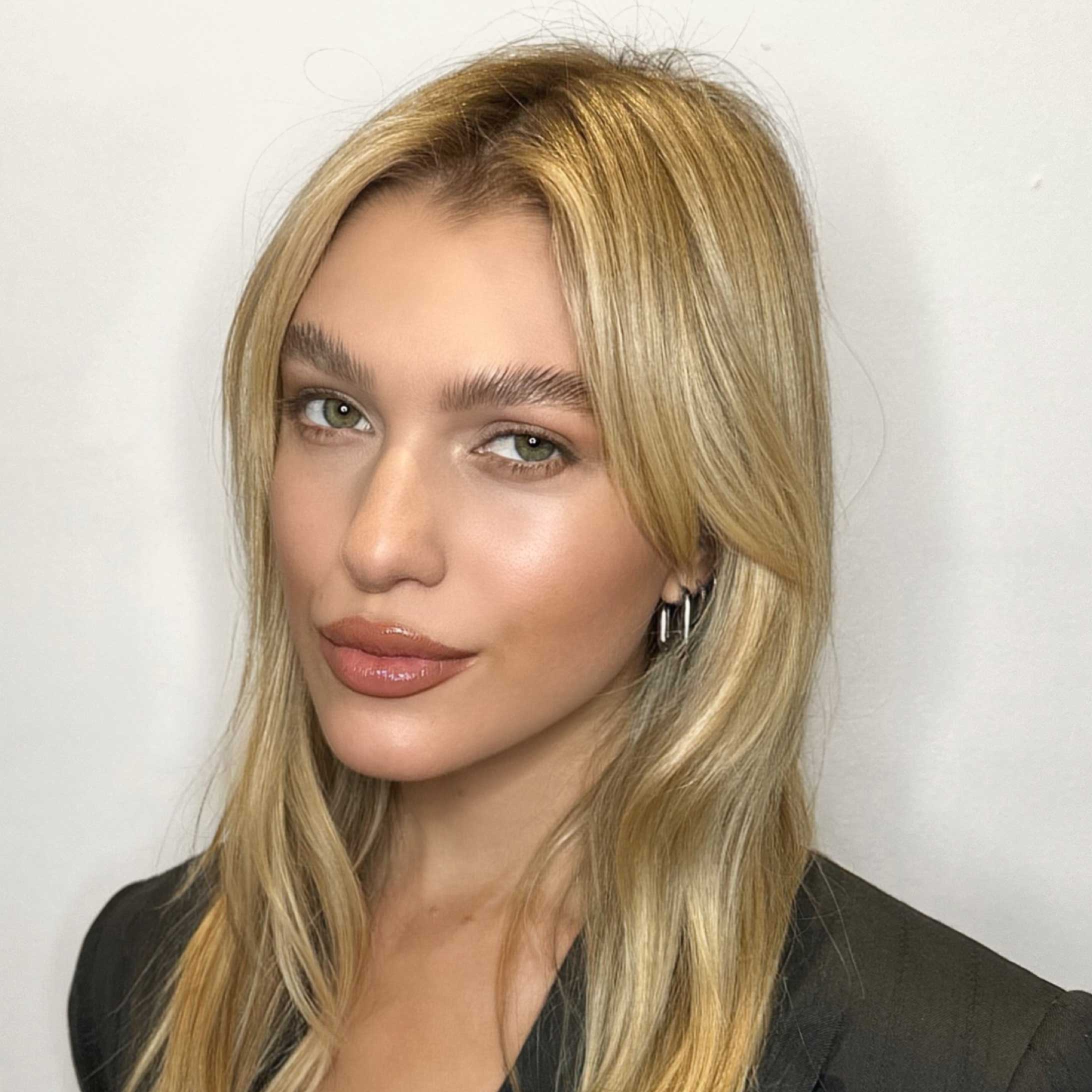 Heaadshot of a woman with blonde hair looking at the camera