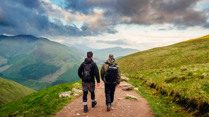 Image of two people wearing walking shoes on mountainside