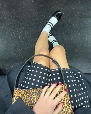 Olivia Rodrigo wears polka-dot skirt, leopard-print bag, white socks, and black platform Mary Janes.