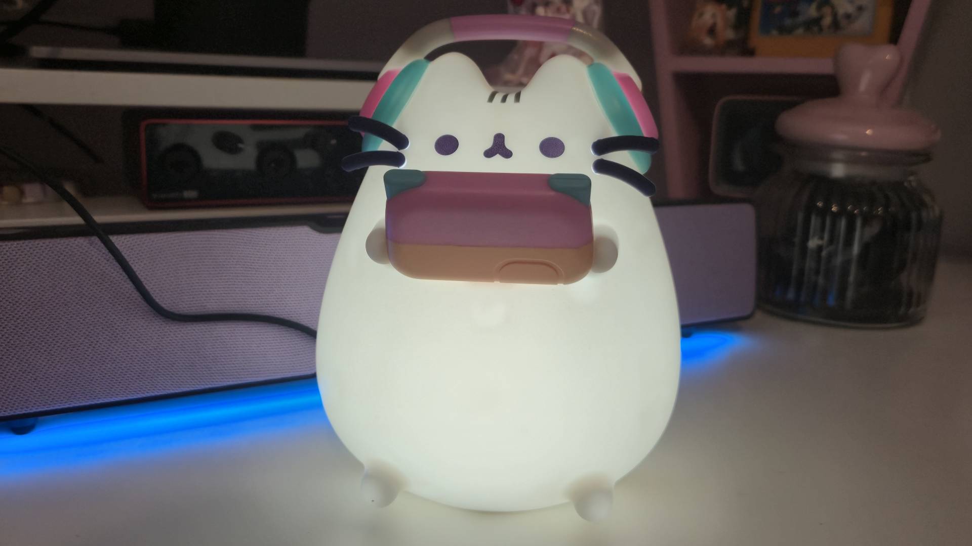 Photo by Rosalie Newcombe of the Pusheen Gamer Lamp lit-up while sitting on a white desk.