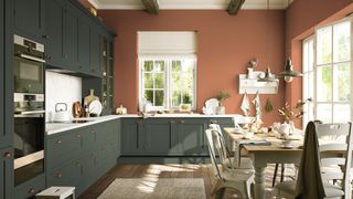 Dark green kitchen cabinets with terracotta painted walls to show two key kitchen trend s2023