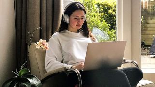 Woman listening to music using Bose noise cancelling headphones 700