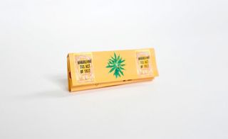 premium rolling papers in a yellow package photographed against a white background