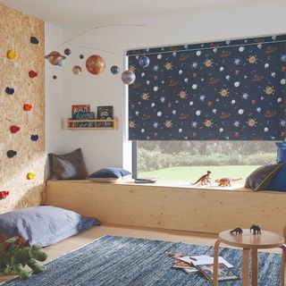 Kids room with planet print roller blind and climbing wall