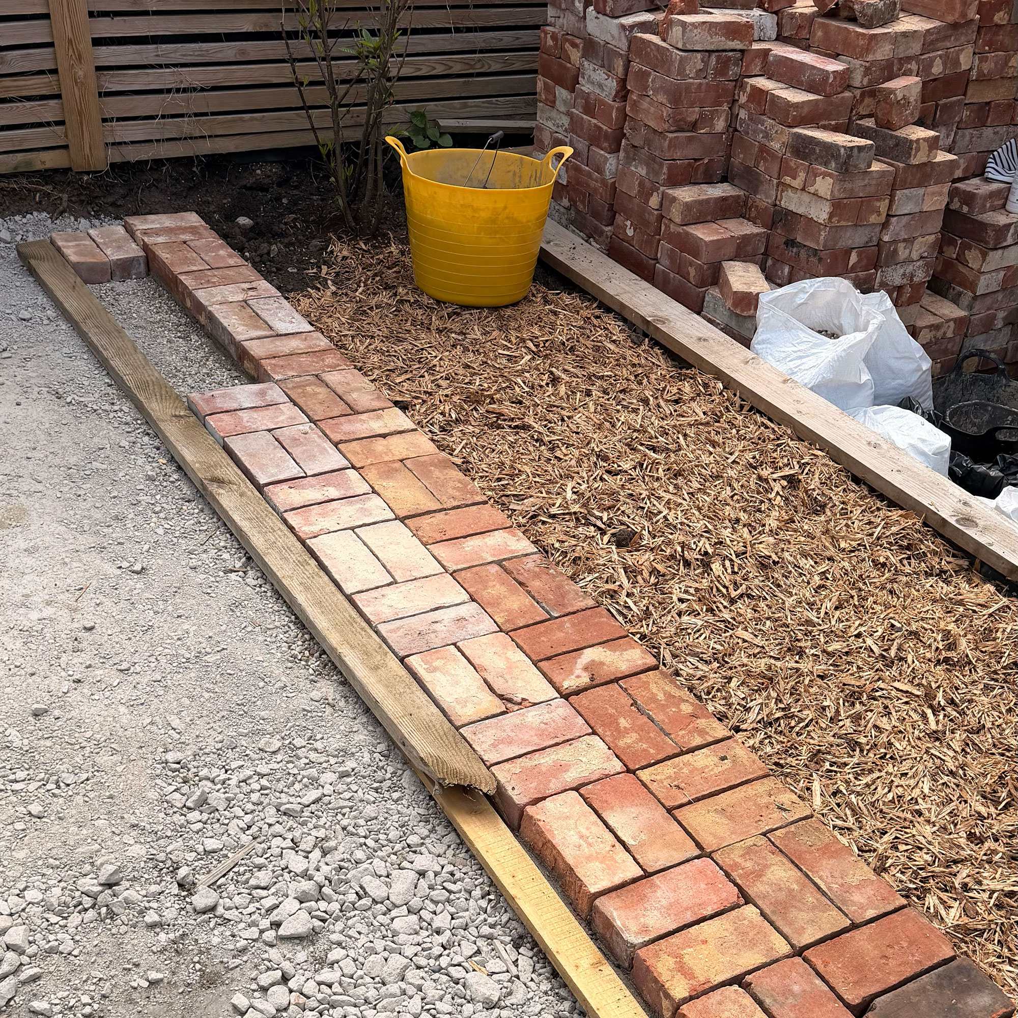 Garden border made of bricks mid-construction