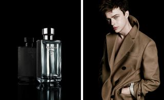 Two side-by-side photos of the silver ’L’Homme Prada’ fragrance and the ’Prada man’ played by Dane DeHaan who is dressed in a brown coat. Both photos have a black background