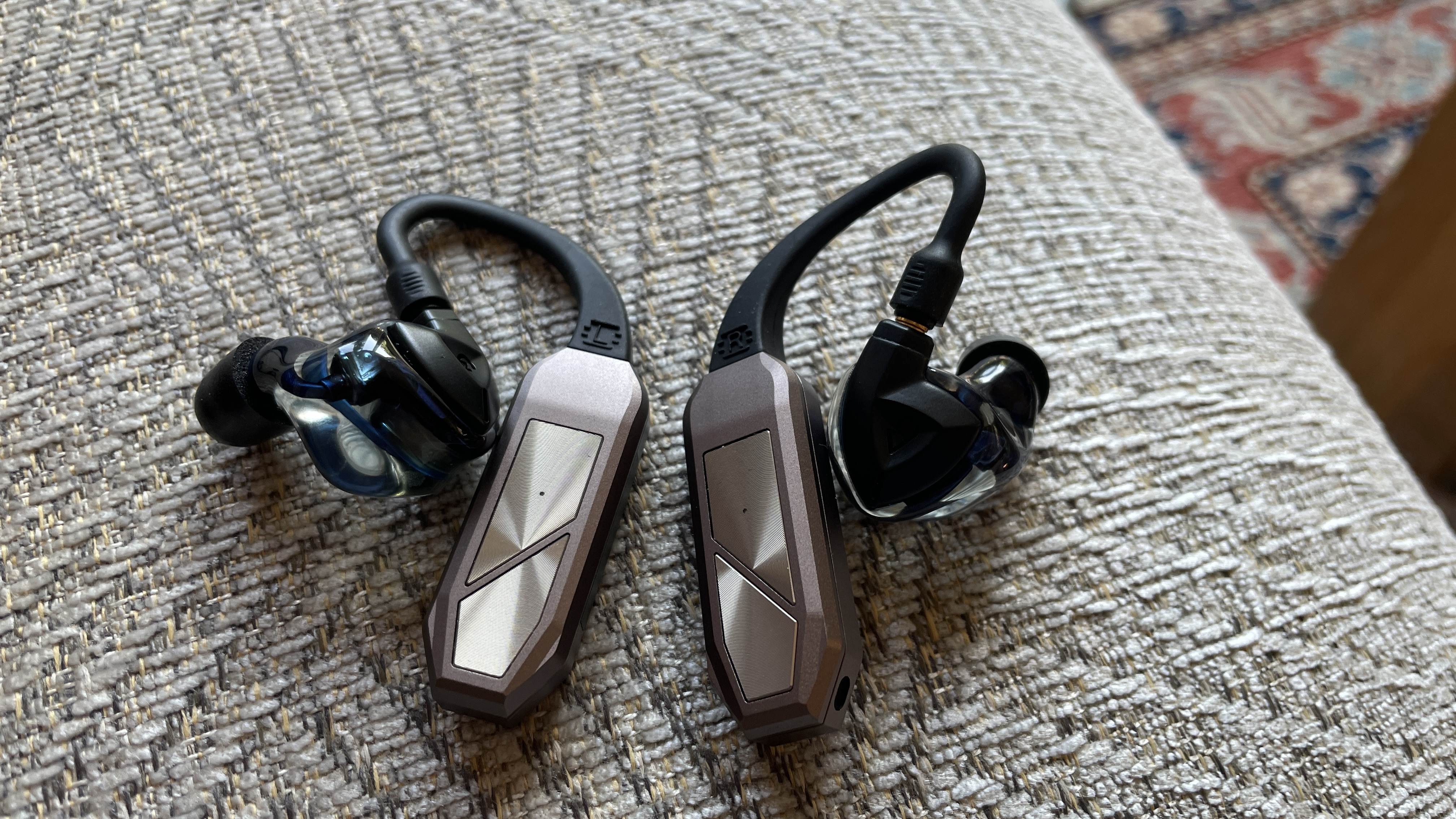 iFi Go Pod in a hand, with high-end wired earbuds and in the case, which accepts even larger earbuds