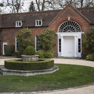 sloping roof house with exposed brick walls and garden