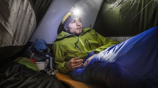 Male hiker in tent at nightime