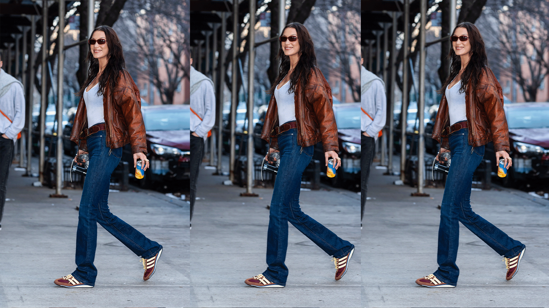 Bella Hadid wears brown bomber jacket, white tank top, dark wash jeans and a brown pair of adidas SL 72