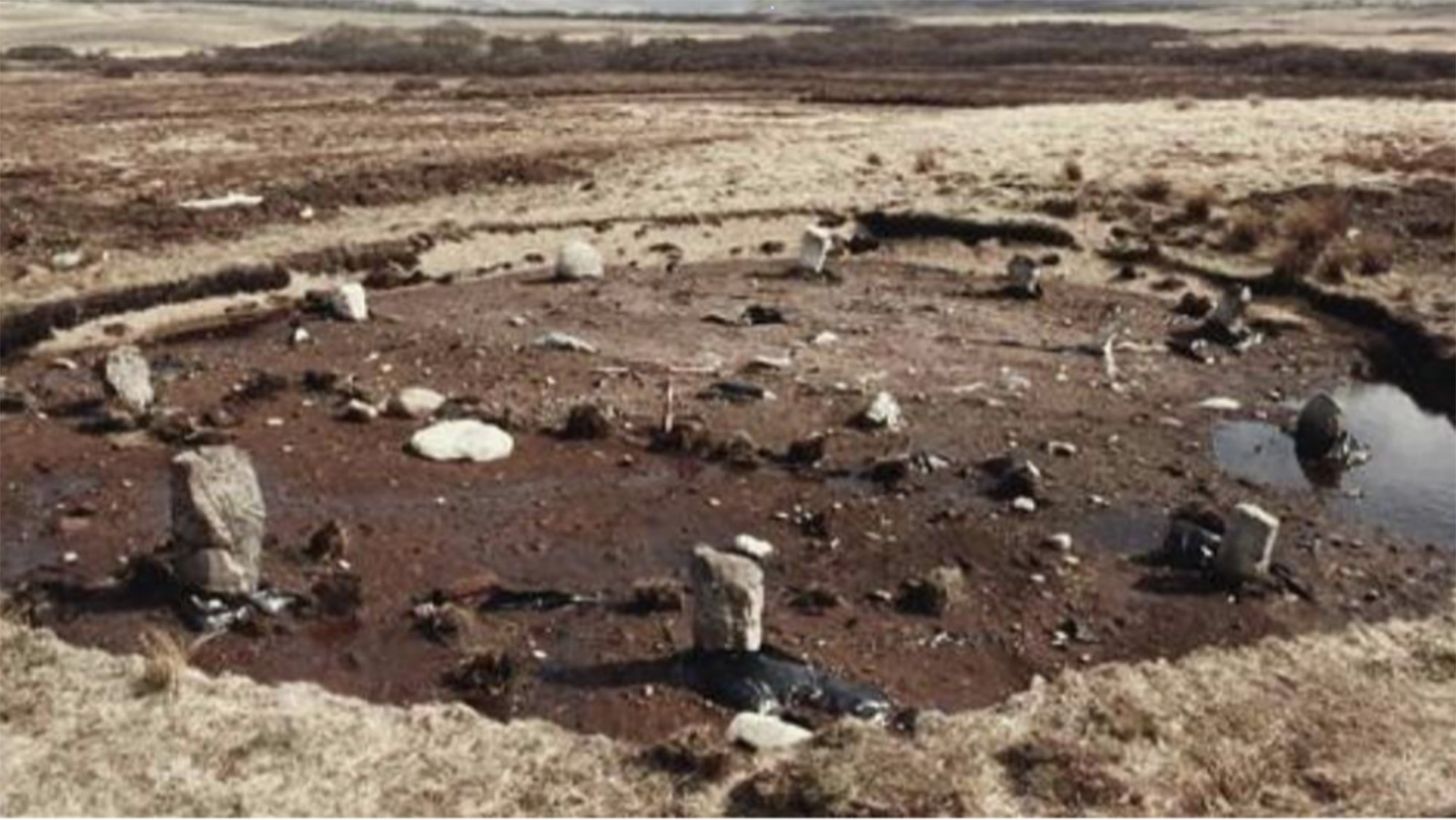 A view of a series of stones in a circle in a mud pit.