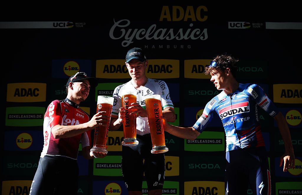 HAMBURG, GERMANY - AUGUST 17: (L-R) Arnaud De Lie of Belgium and Team Lotto on second place, race winner Rory Townsend of Ireland and Q36.5 Pro Cycling Team and Paul Magnier of France and Team Soudal Quick-Step on third place celebrates on the podium ceremony with a beer after the 28th Hamburg Cyclassics 2025 a 207.4km one day race from Buxtehude to Hamburg / #UCIWT / on August 17, 2025 in Hamburg, Germany. (Photo by Ronny Hartmann/Getty Images)