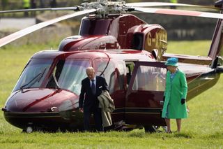 Queen Elizabeth II and Prince Philip, Duke of Edinburgh arrive by helicopter in front of the Rock of Cashel on May 20, 2011