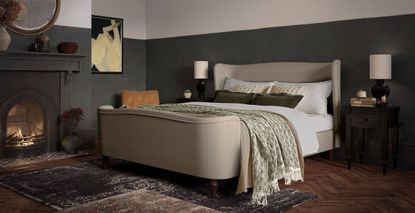 Image of a room with a beige bed and carpeted wood floor