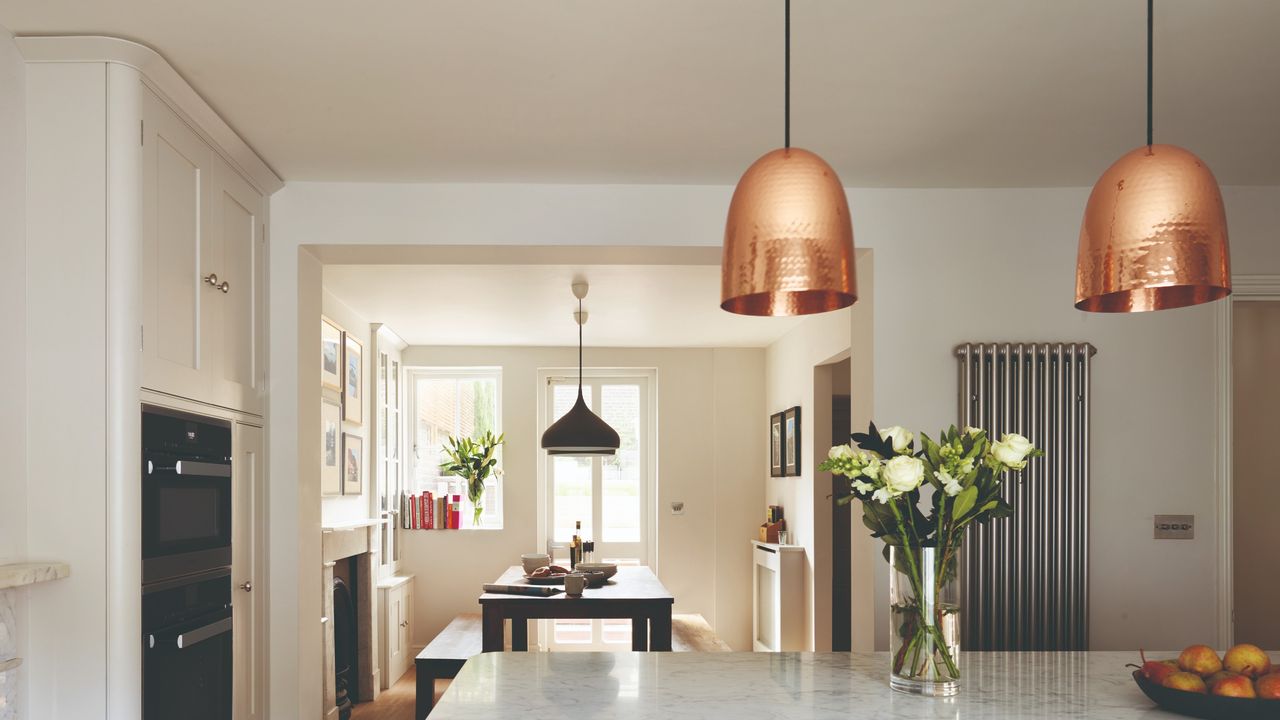 A large kitchen with copper pendant lights