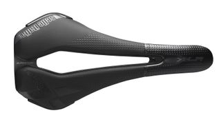 A stock image of the Selle Italia X-LR Kit Carbonio Superflow saddle, with a ultra-wide central cut out, long nose, plastic bumpers at the flanks and dotted padded upper