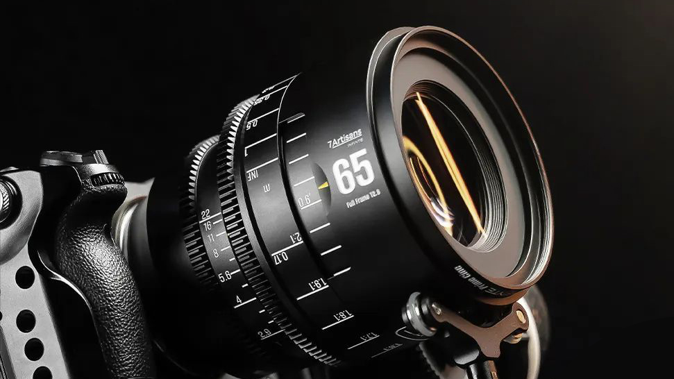 Close-up of a high-quality camera lens (7Artisans INFINTE 65mm T2.9 2x Macro Lens) mounted on a camera body, showcasing its features and focus markings in dramatic lighting