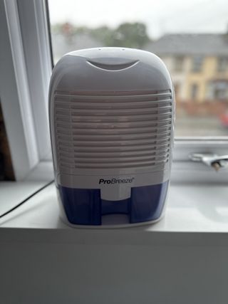 The ProBreeze 1500ml Mini Dehumidifier on a windowsill