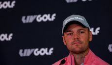 Kaymer sits at a press conference with LIV Golf logos behind him