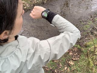 A hiker looking at the map on her GPS watch on the trail