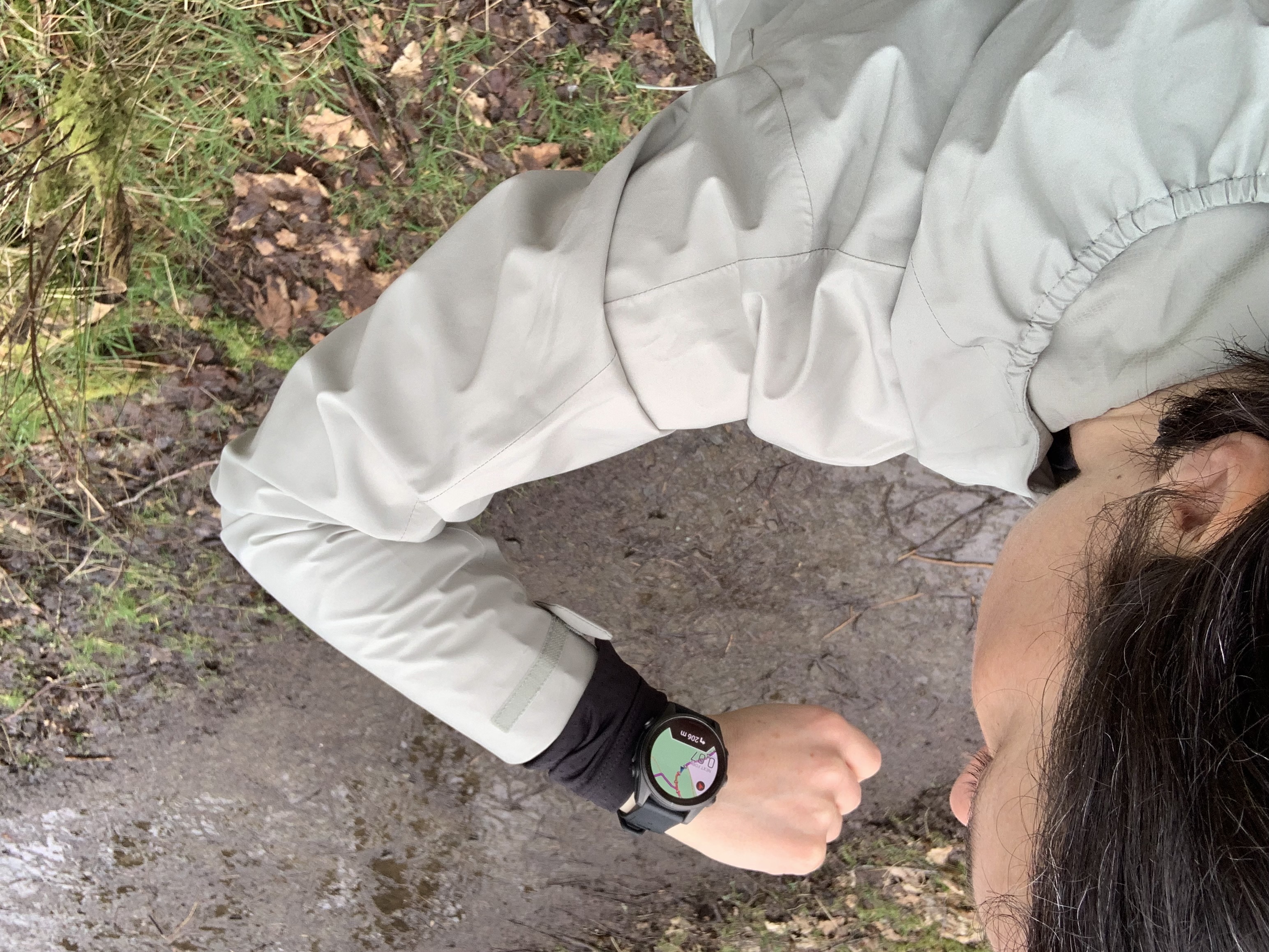 A hiker looking at the map on her GPS watch on the trail