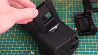 A film holder being put into a Valoi easy35 film scanner on a green lined cutting mat