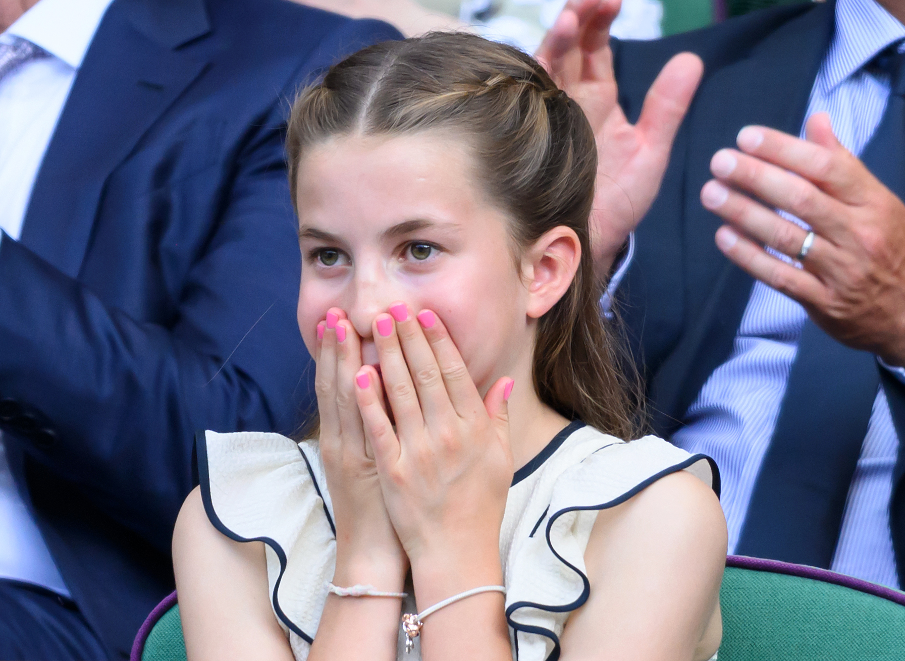 Princess Charlotte wearing pink nail polish and covering her mouth at Wimbledon