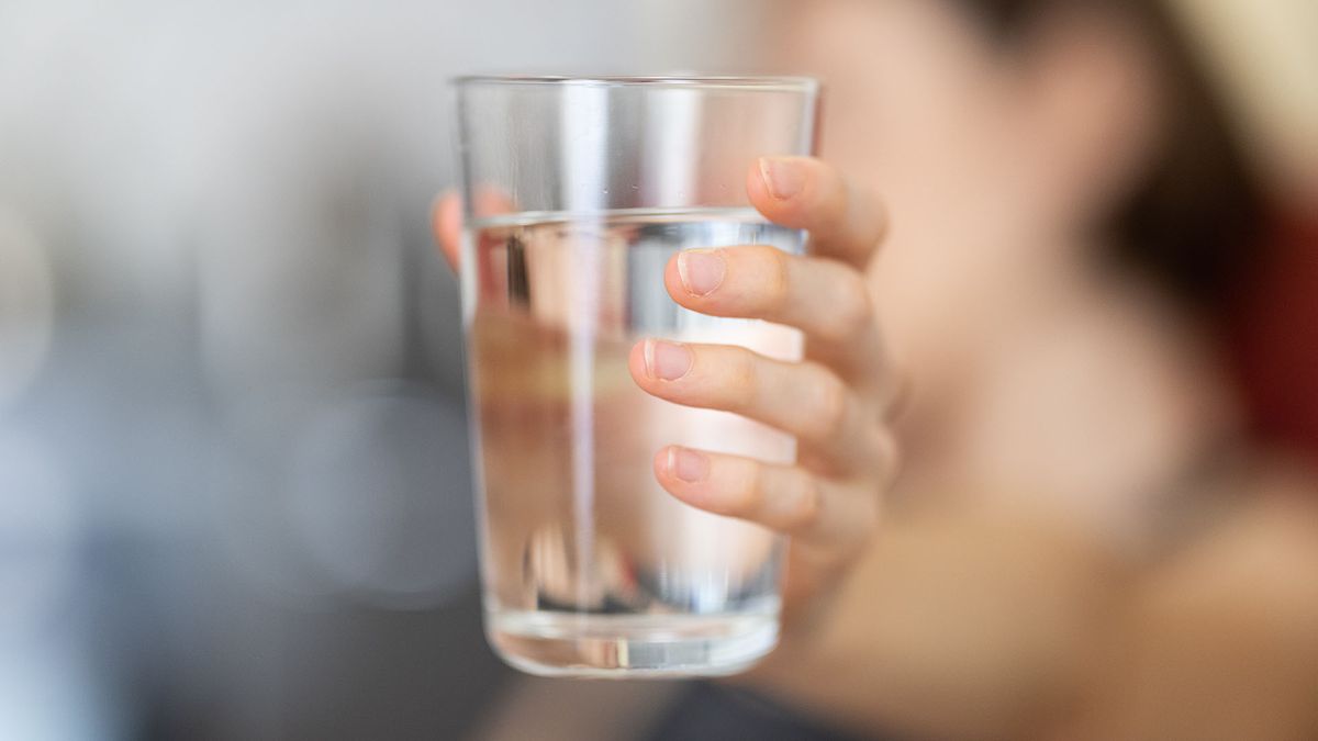 Person holding a glass of water