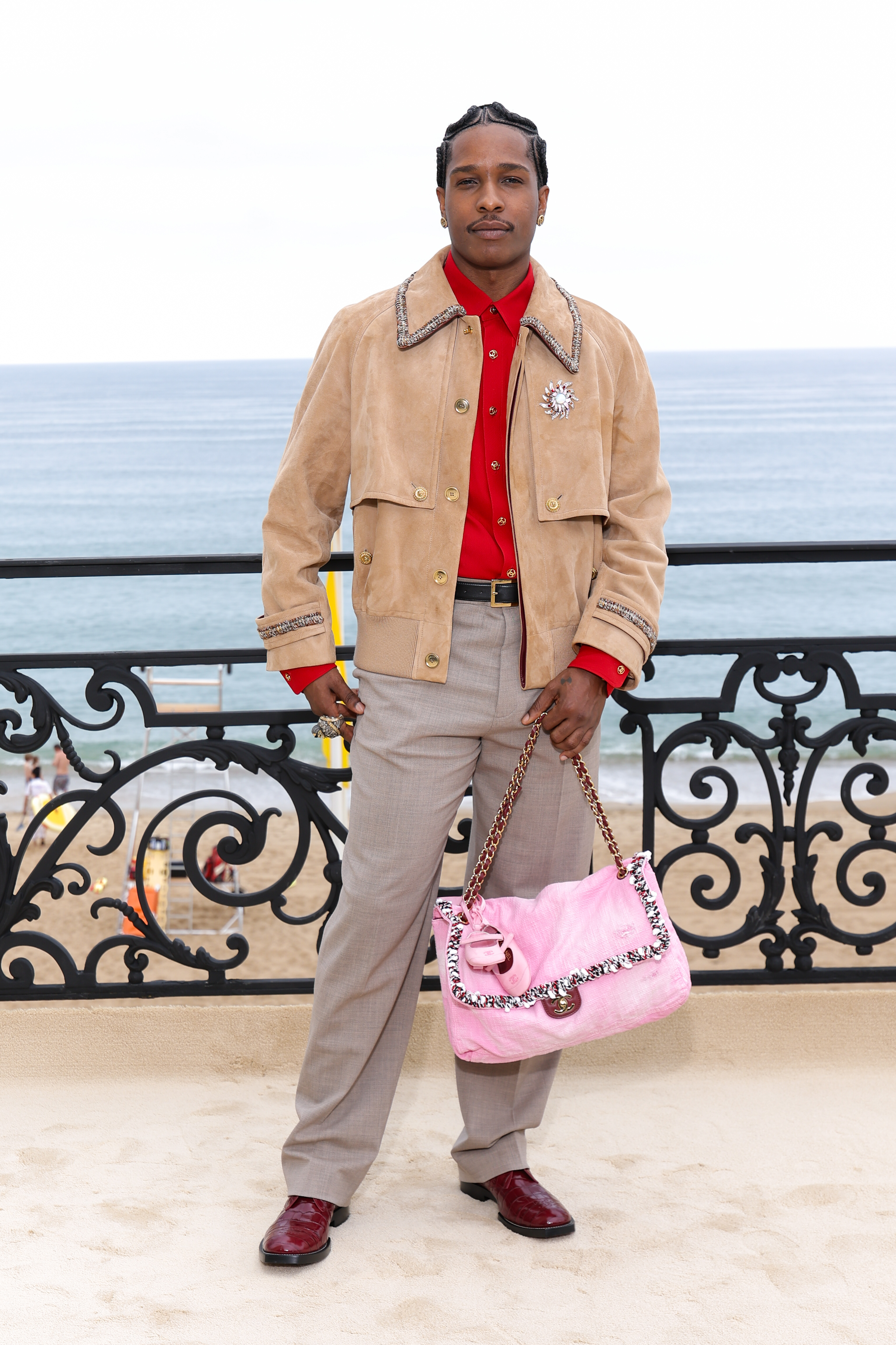 A$AP Rocky attended the Chanel Cruise 2026 fashion show with a pink Chanel Flap bag and a girl dad bag charm