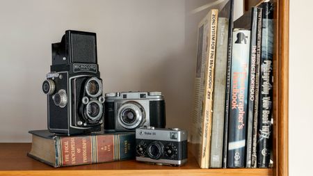 Bookshelf with old cameras and a selection of books on photography