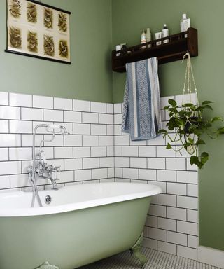 A bathroom with green bathtub, green wall paint decor and white tiles