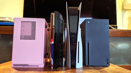 A photo showing a size comparison of a Sony PlayStation 5 consoles against a variety of other gaming devices