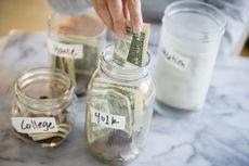Mixed race woman saving money in jars