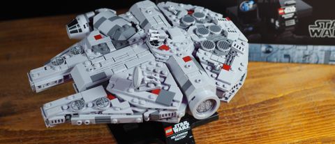 A close-up view of the Lego Millennium Falcon on a stand, on a wooden surface