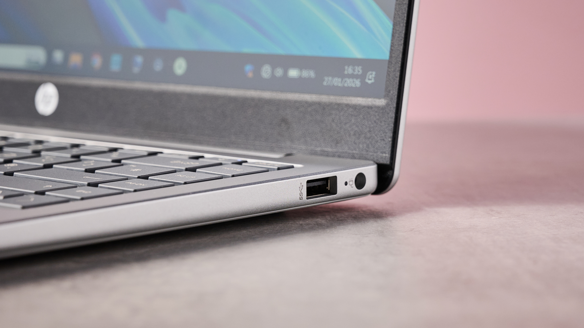 Close-up of ports on right-hand side of HP Laptop 14, on desk with pink wall in background