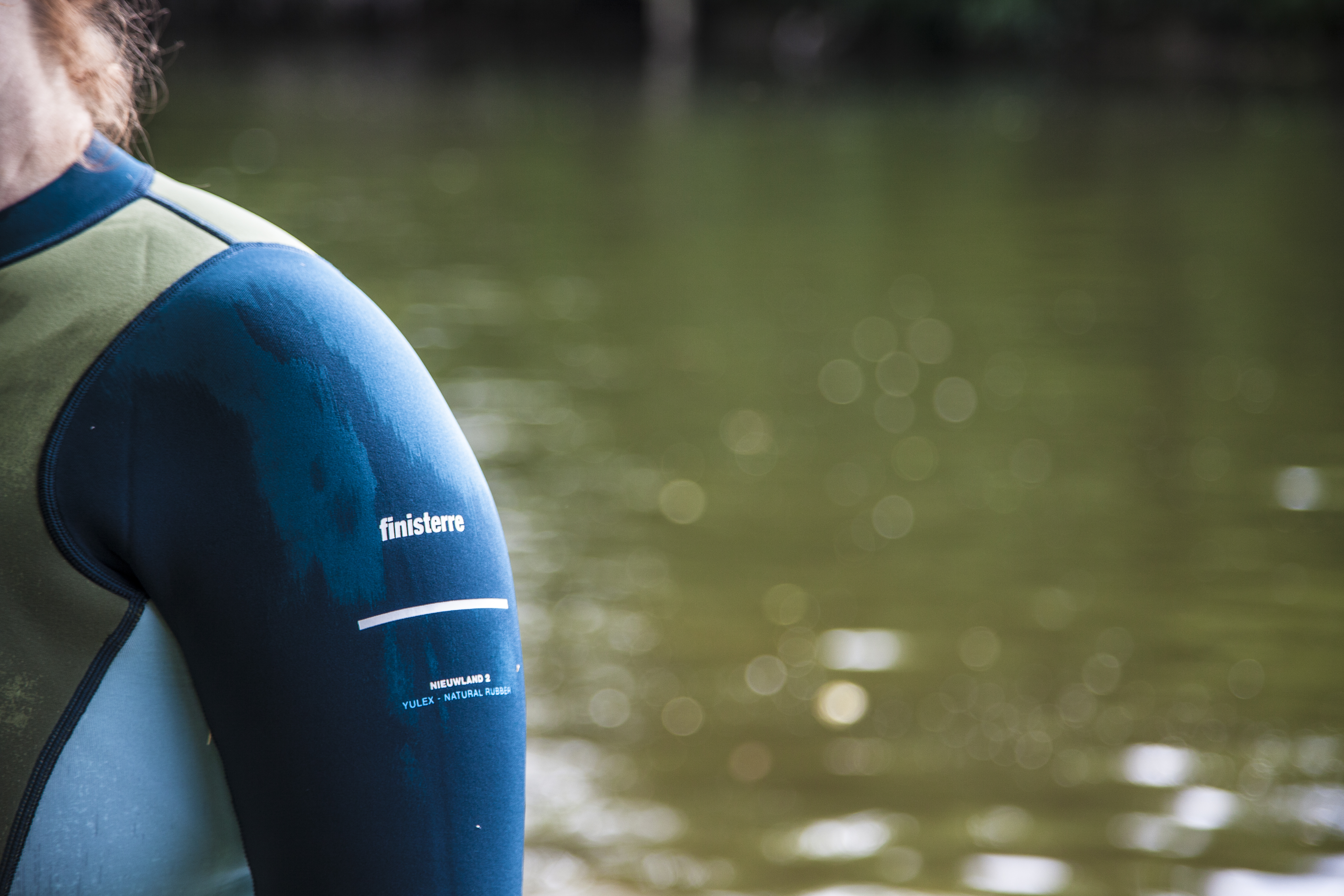woman wearing Finisterre wetsuit standing in water