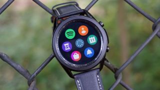 A Samsung Galaxy Watch 3 hooked over a fence