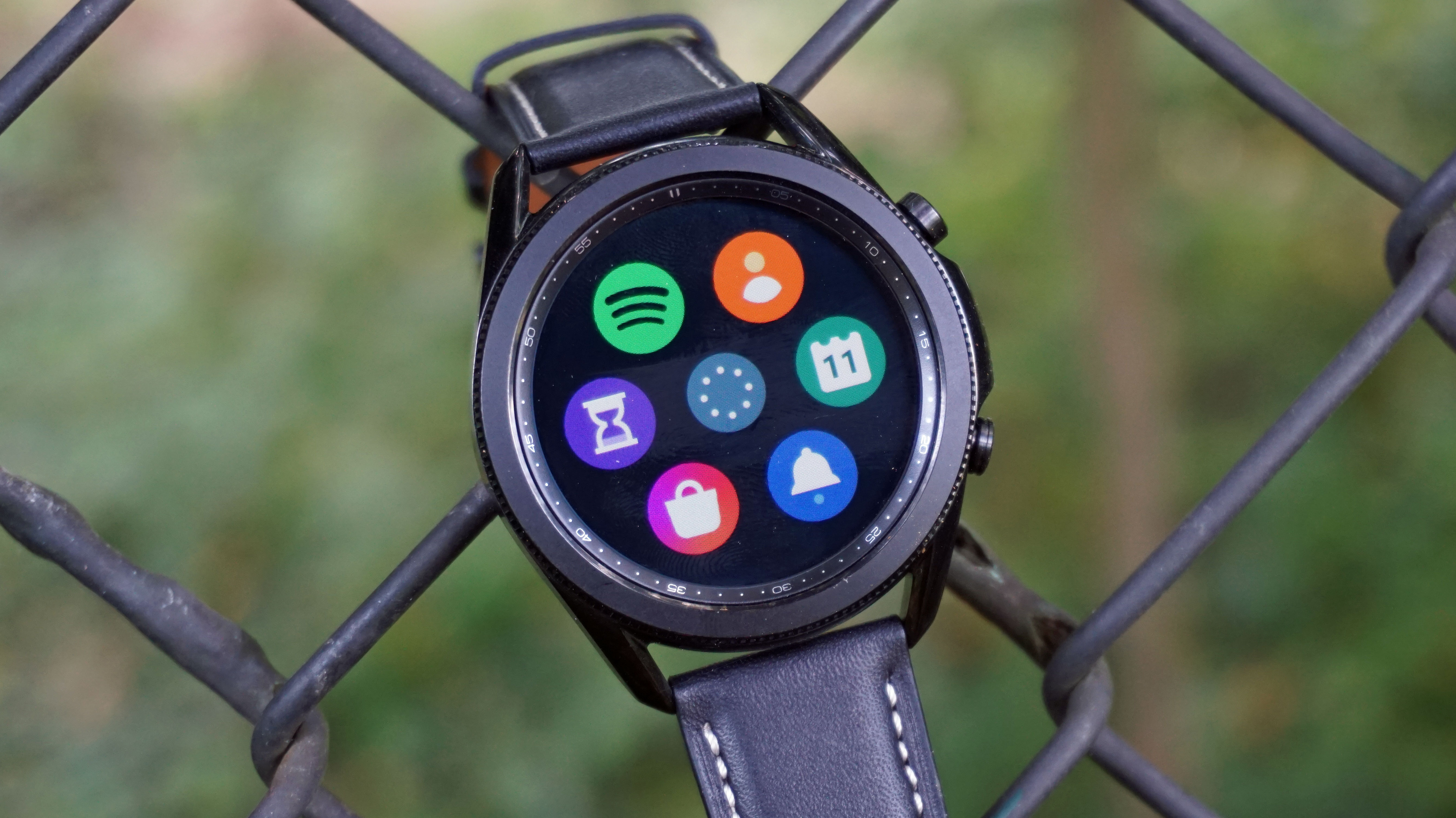 A Samsung Galaxy Watch 3 hooked over a fence