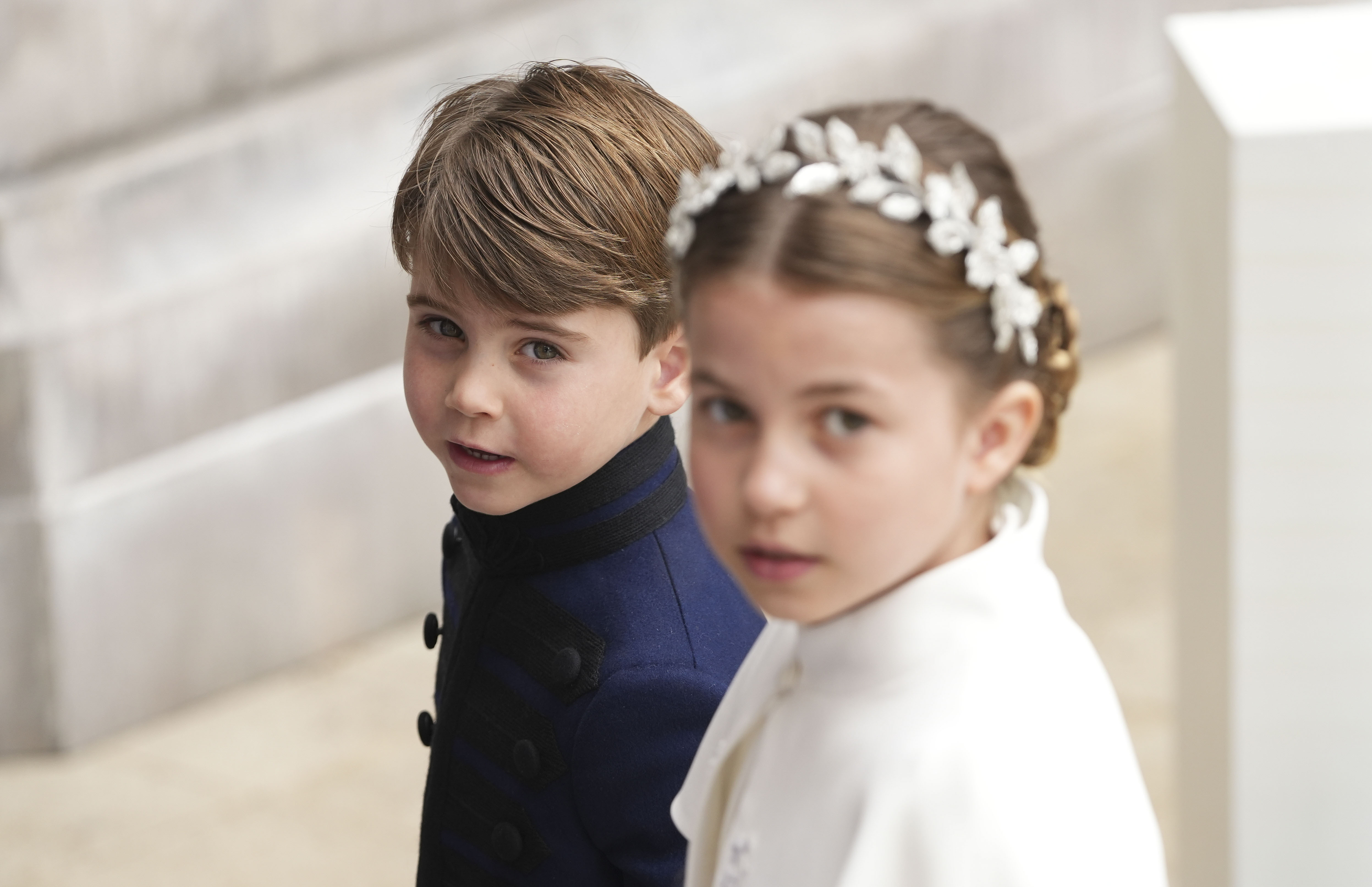 Prince Louis and Princess Charlotte looking up at the camera at King Charles's coronation